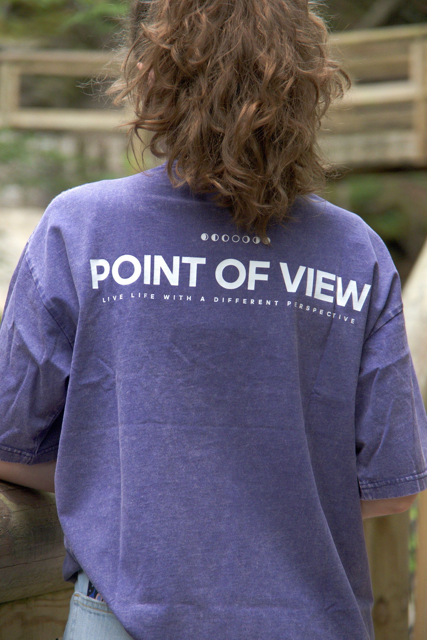 Person wearing a purple t-shirt with 'POINT OF VIEW LIVE LIFE WITH A DIFFERENT PERSPECTIVE' on the back.